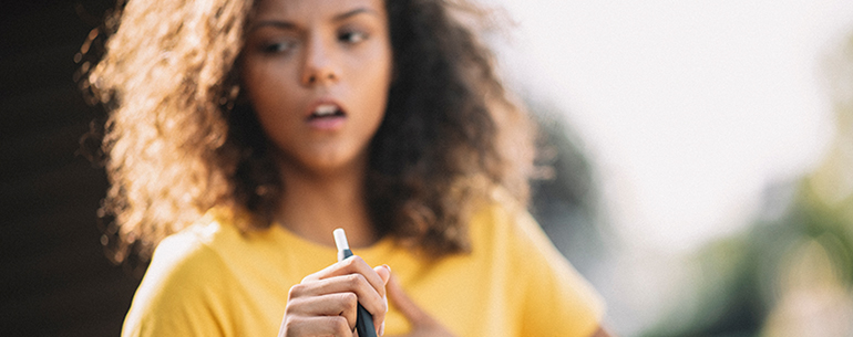 girl smoking e-cigarette and coughing