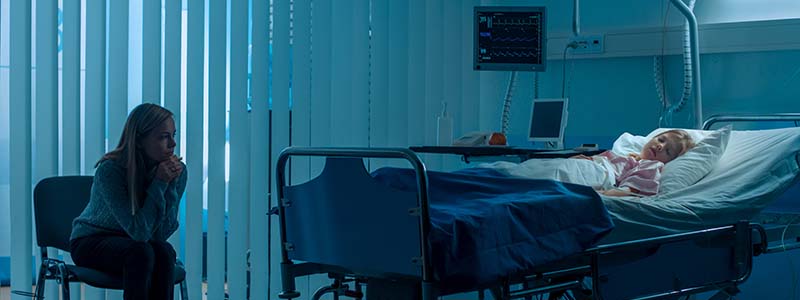 Mother sitting at sick child's bedside