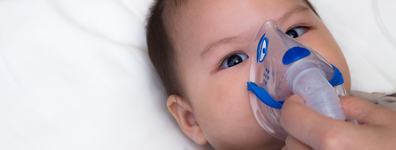 baby with oxygen mask