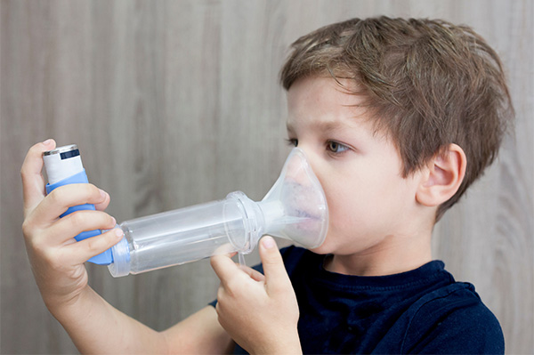 Boy with inhaler with spacer